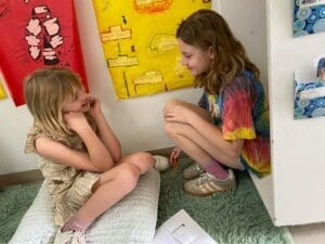 Two elementary students smile in corner at GT school.