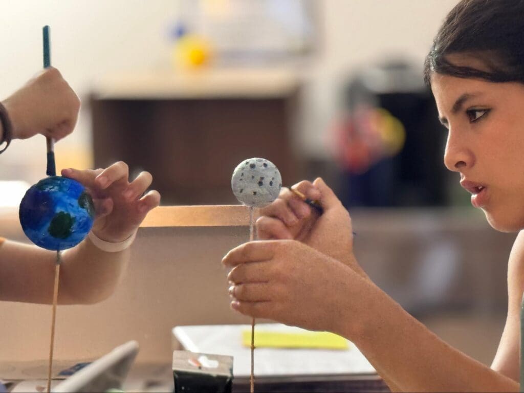 Middle school students create planets at STEM school.