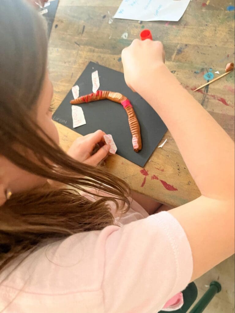 Elementary student labels parts of worm at STEM school.