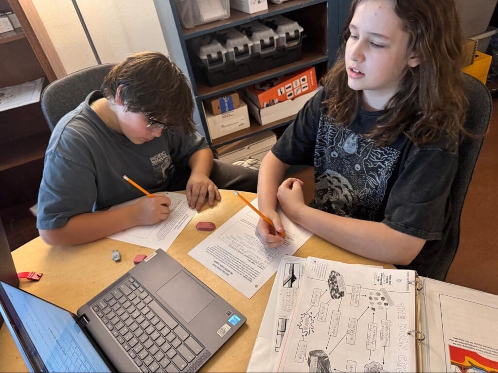 Middle school students work on computer at STEM school.